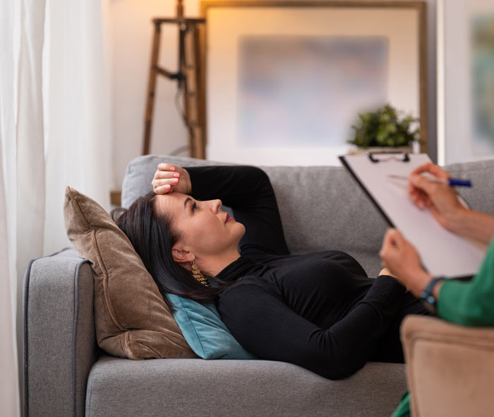 woman lying on a couch during therapy session